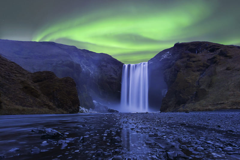 Northern Lights aurora borealis over Skogafoss waterfall in Iceland