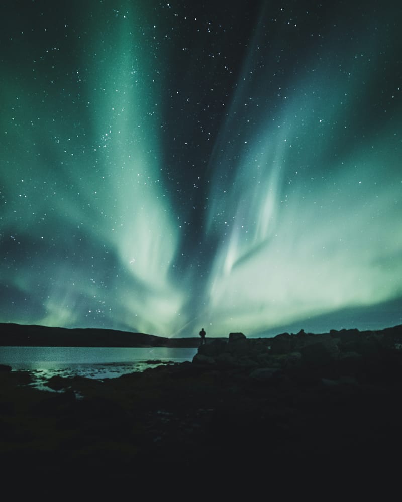 Traveler in warm layers standing against dramatic Iceland landscape