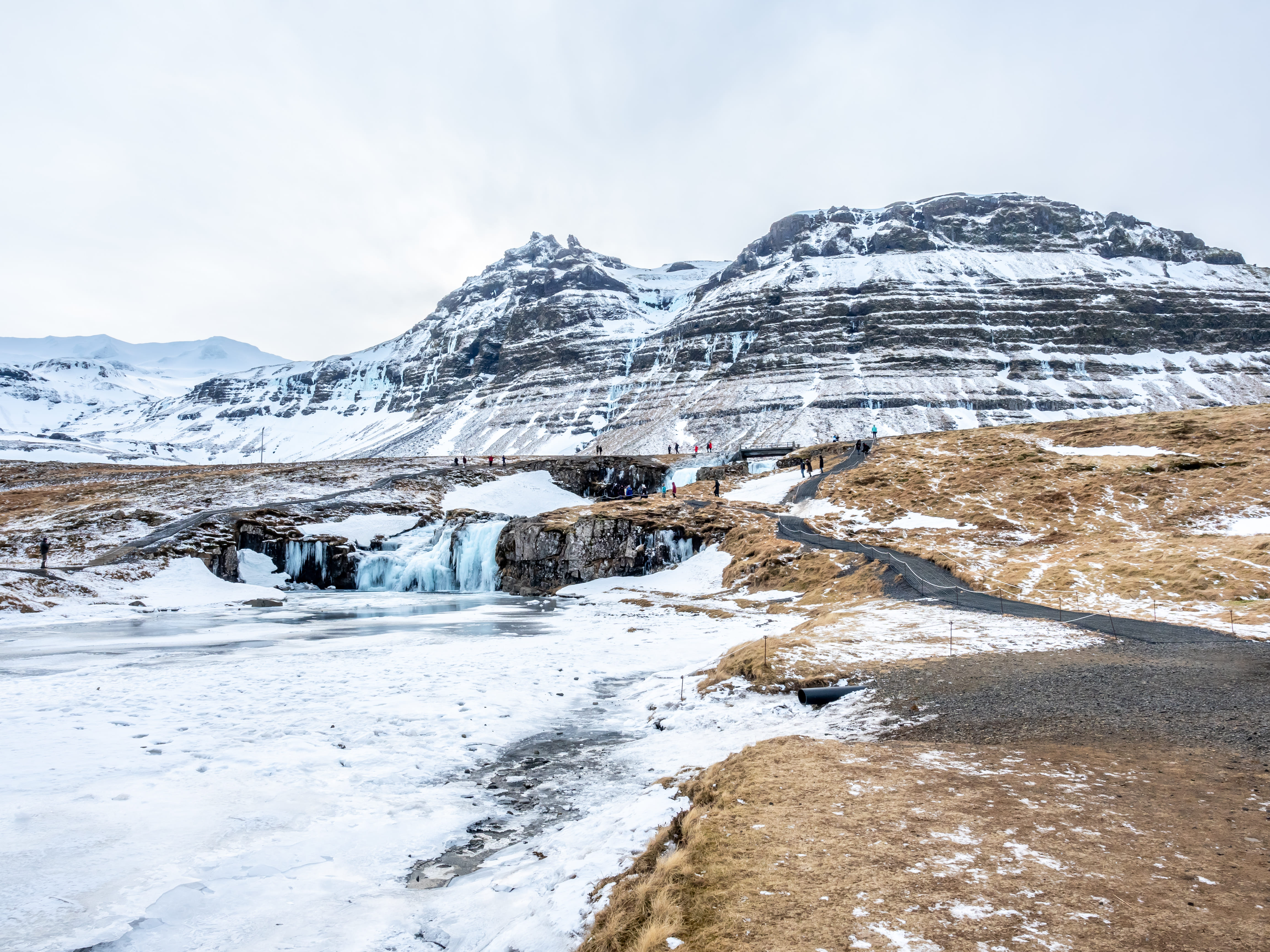 Kirkjufell mountain and frozen waterfall in winter