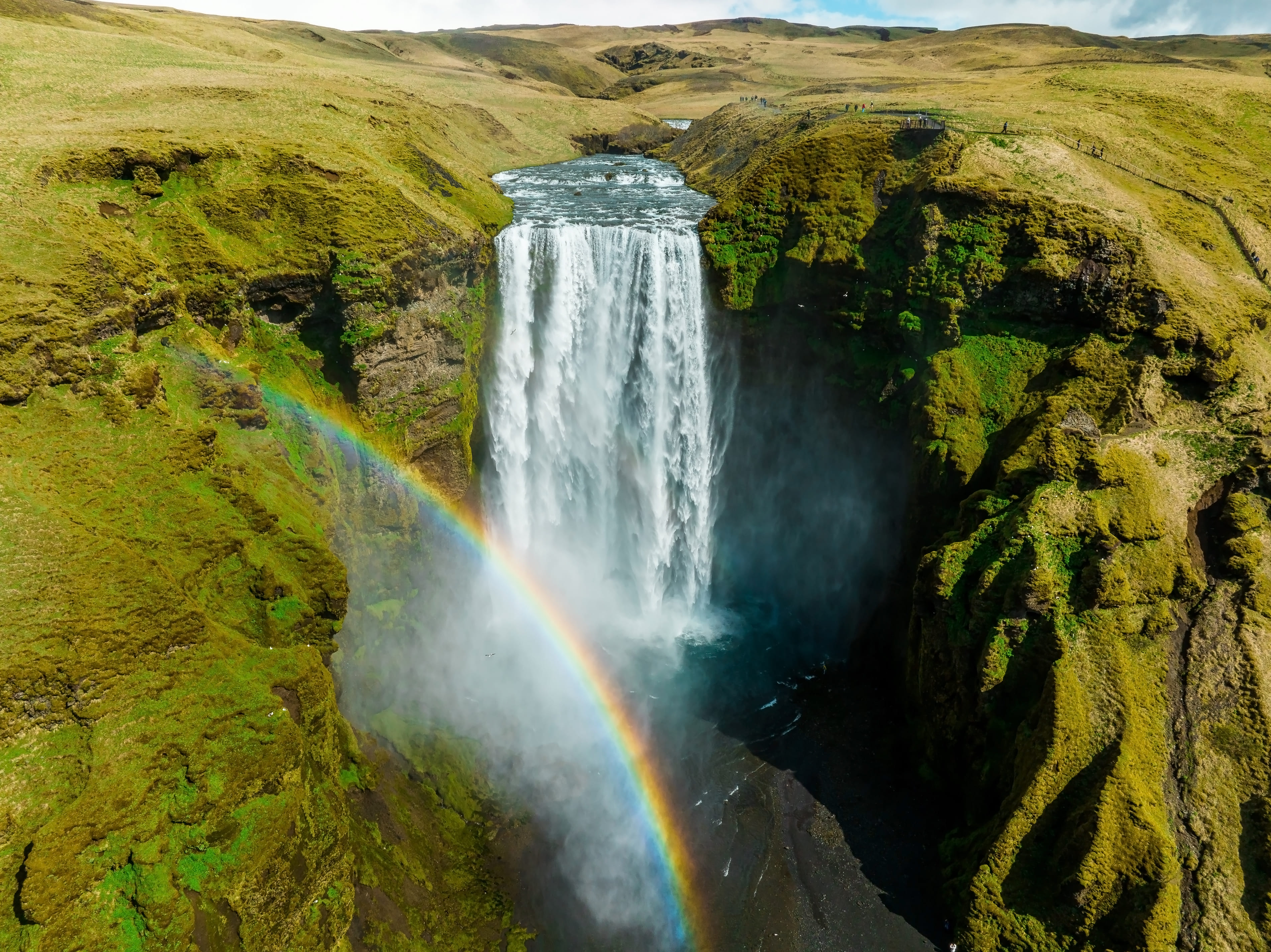 Skogafoss waterfall with rainbow at sunset in Iceland