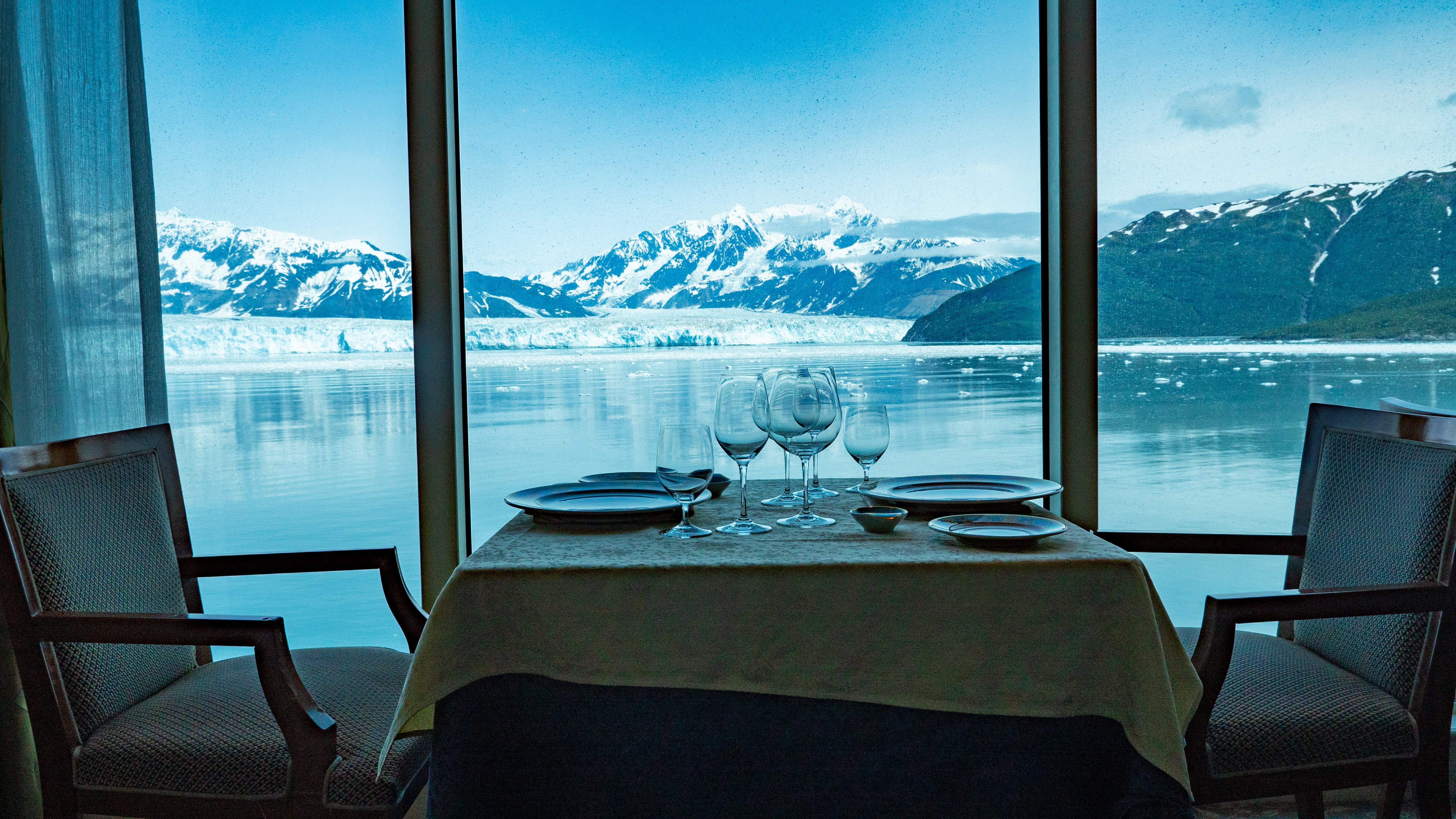 Empty restaurant cafe seats interior with panoramic windows at glacier bay nature view