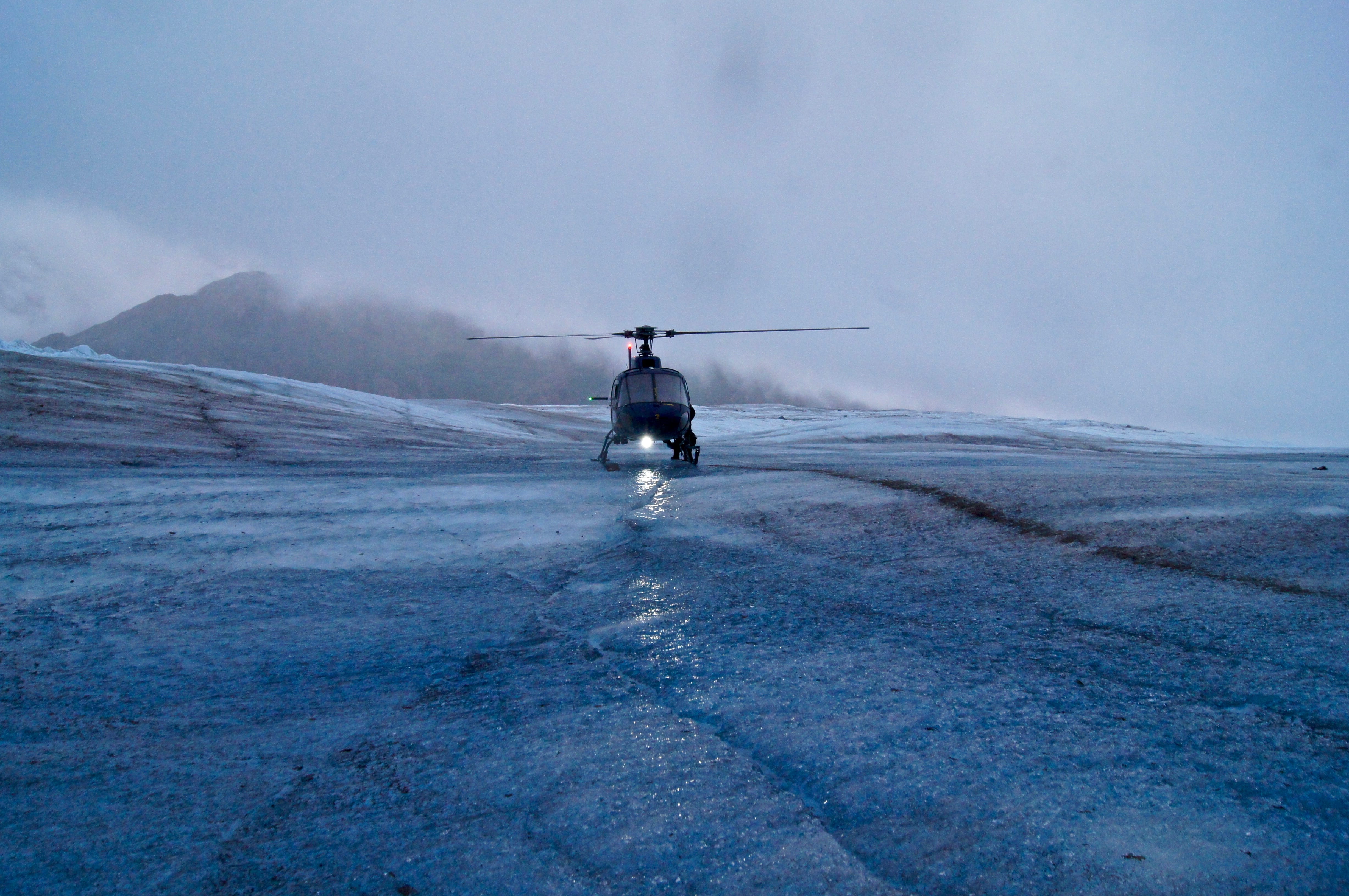 Helicopter atop the Mendenhall glacier ready for take off in the foggy mist