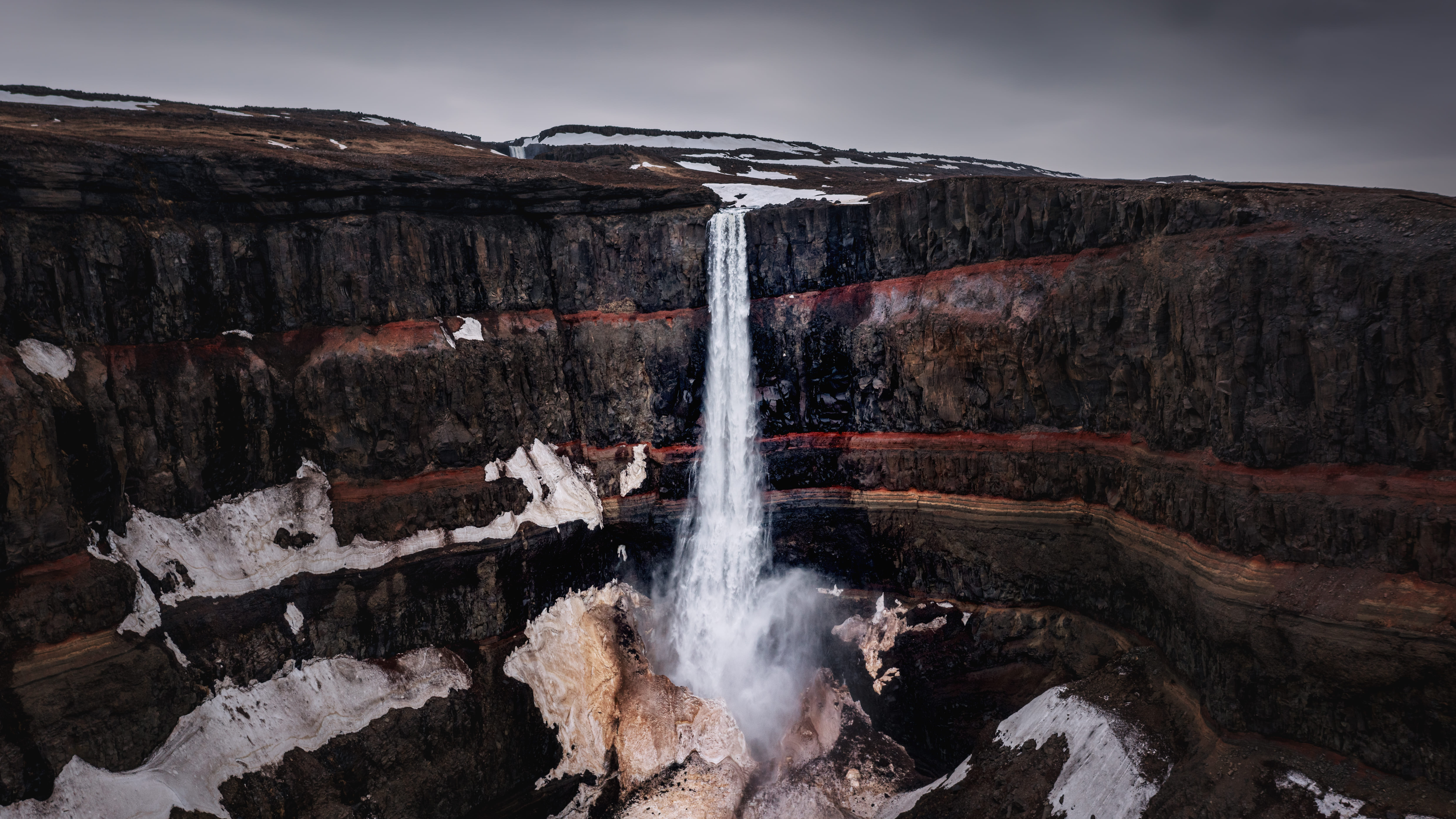 Moody aerial drone view of volcanic Hengifoss waterfall northern Iceland